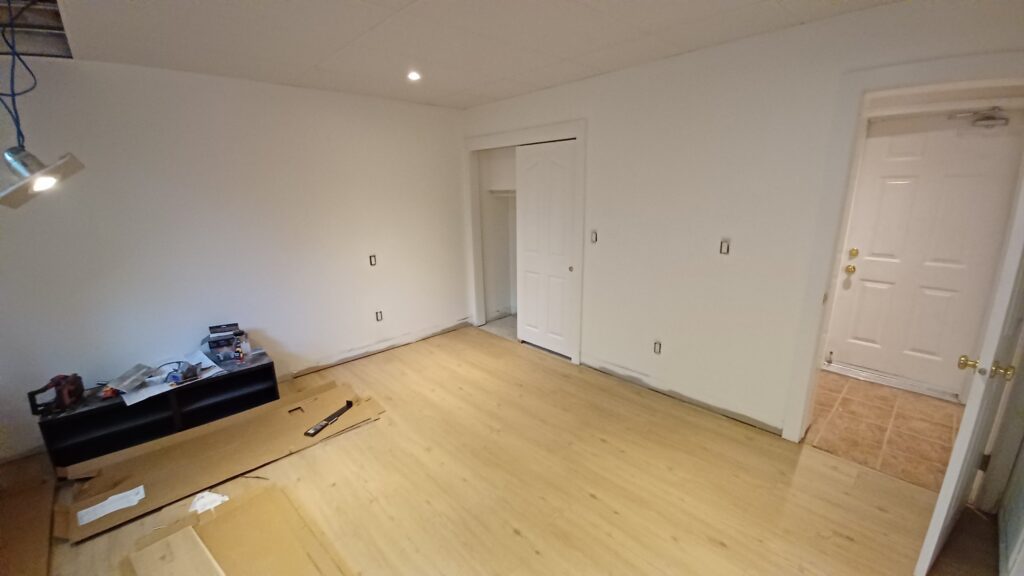 Finished basement room with painted walls, closet and new laminate flooring