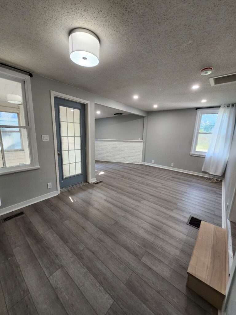 Living room with new vinyl plank flooring, pot lights and fresh paint