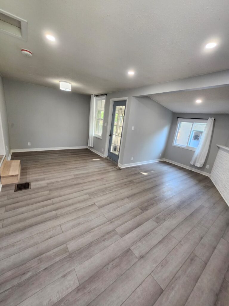 Open living space with new vinyl plank flooring and fresh paint