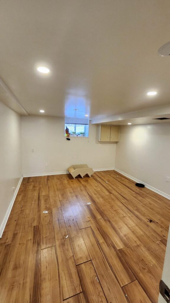 Finished basement room with new plank flooring and pot lights