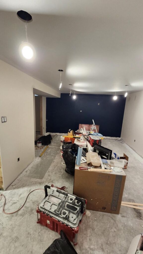 Basement living area with painted walls and a navy accent wall
