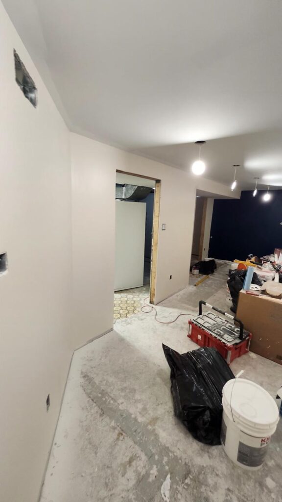 Basement hallway with finished and painted walls and pot lights