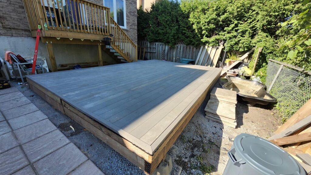 Large grey composite deck built in a backyard