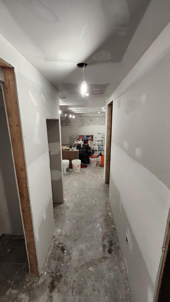 Basement hallway with new drywall hung and ready for finishing