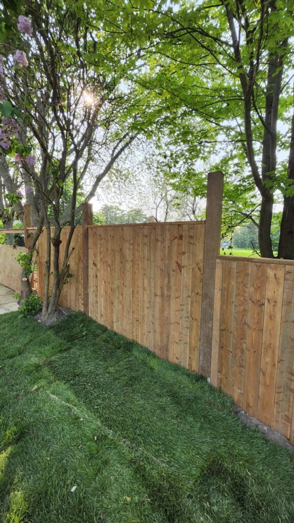 New wood privacy fence along a freshly sodded lawn